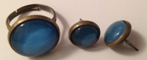 Boucles d’oreilles puces cabochon 10 mm bleus unis, fermoir en plastique transparent : 8€ la paire. Bague cabochon 16 mm, réglable 10€